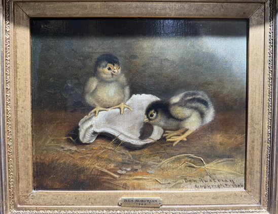 Photo of small oil painting in gilded frame on display at museum depicting a pair of chicks (baby chickens?) yellow-brown with black markings, with an upturned white shell (oyster?), chick to left perched on it and chick to right bent over looking into it, in a barn setting (straw-covered ground and brown wall behind) Artist name & date visible in lower right corner