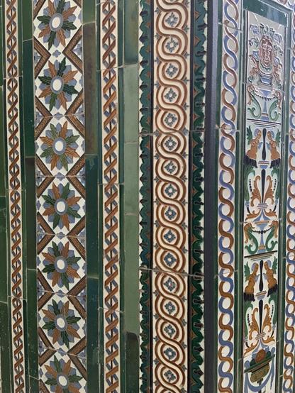 Mosaico de colores verdes, rojos y dorados en la pared del ayuntamiento de Madrid