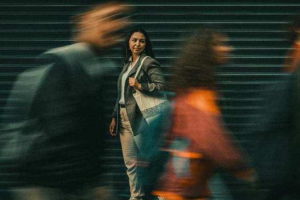 pedestrians passing by woman standing on street