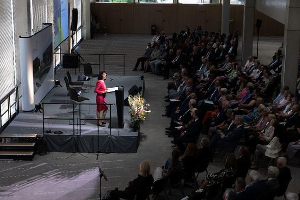 Landtagspräsidentin Aras steht auf der Bühne und hält eine Rede vor Gästen