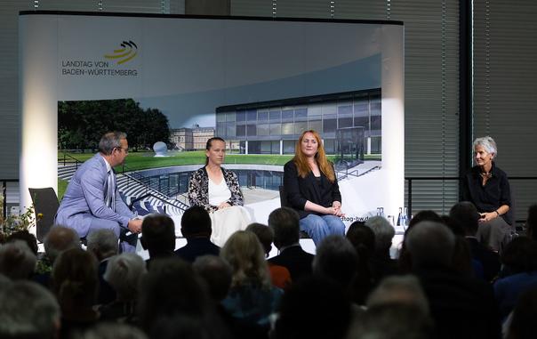 Vier Personen sitzen auf der Bühne bei der Podiumsdiskussion