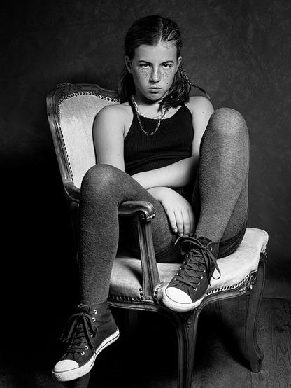 Studio portrait of a 10-year-old girl sitting on a chair
