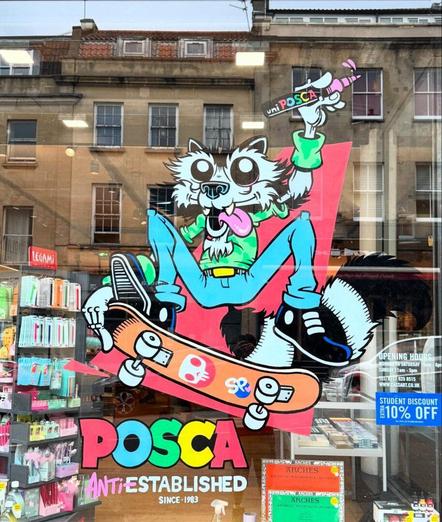 A window display shows a cartoon raccoon holding a Posca marker and riding a skateboard, with art supplies visible inside the shop and "POSCA ANTIESTABLISHED" text on the glass.