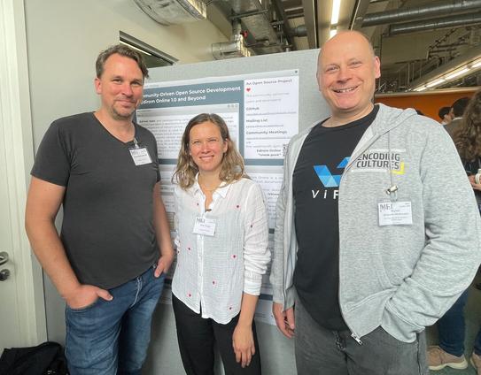 Drei Kolleg:innen von NFDI4Culture stehen vor einem Poster mit der Aufschrift "Community-Driven Open Source Development of Edirom Online 1.0 and Beyond"