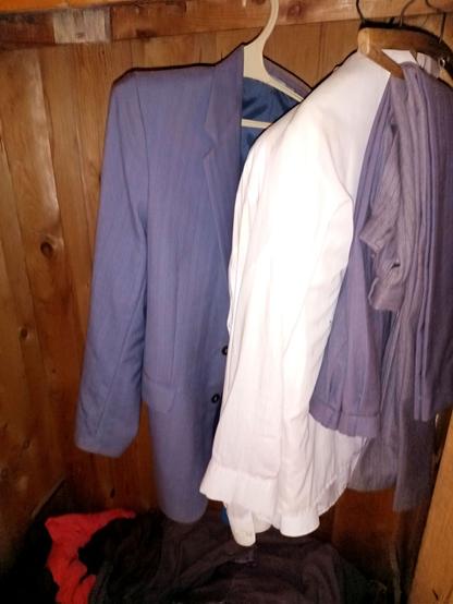 A grey pinstripe suit, folded trousers and stack of white shirts hanging in an old wooden wardrobe. They look very much like a standard soviet suit certain politicians were wearing in the 80s.