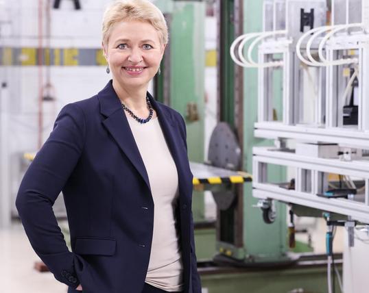 Beate Heinemann im Labor, lächelt in die Kamera. Foto: DESY.