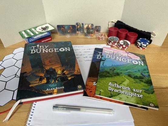 Spielmaterial hinter einem Sichtschirm, bereitgelegt für den Spielleiter des Pen and Paper-Rollenspiels „Tiny Dungeon“
