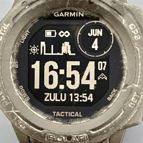 dirty black wristwatch face displays time, date, solar power curve, with an infinity symbol beside the battery icon