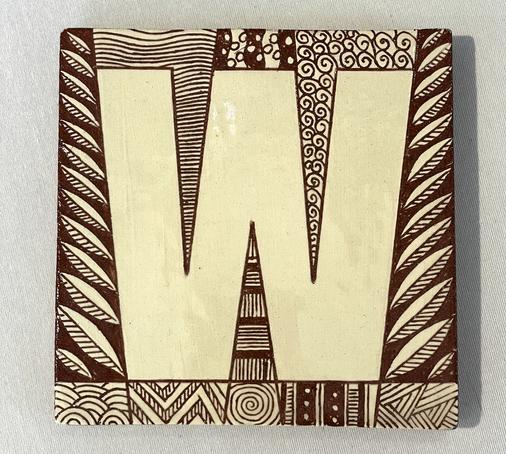 Capital W design ceramic tile decorated with sgraffito patterns.