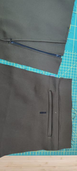 brown material showing an attempt at a welt pocket and a zipped pocket. There is also some wobbly top stitching on evidence.