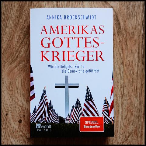 Das Buch AMERIKAS GOTTESKRIEGER. Ein Kreuz mit USA-Flaggen.