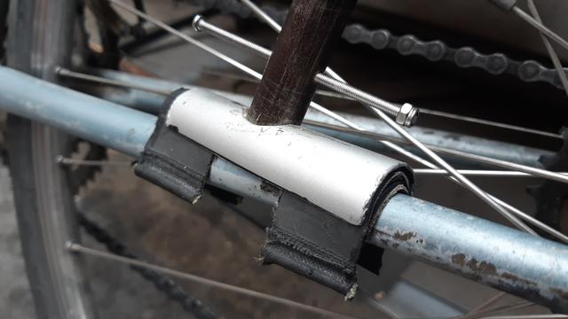 Le bout de balai en aluminium fixé sur la base d'un vélo devient le socle pour un mat de drapeau porte comm, avec 2 épaisseurs de pneu Hutchinson collé en anti-dérapant et pour ne pas abîmer la peinture du vélo.