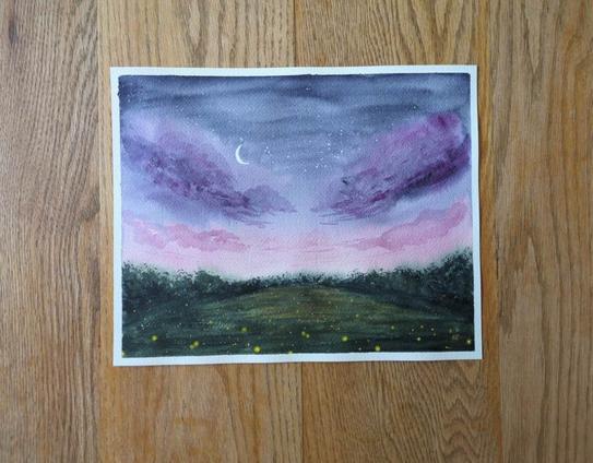 This is a watercolor painting of Fireflies in a Meadow in landscape orientation. The top 2/3 is the sky at dusk going from indigo with stars and a crescent moon to purple with clouds to pink with smaller whispier clouds towards the horizon line. The bottom third is the meadow with a tree line at the horizon line. The meadow is filled with fireflies. Towards the bottom are bigger closer ones and they get smaller as the move towards the tree line.