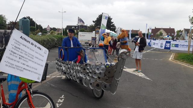 2 enfants à bord d'un bateau à 2 roues joliment décoré de vieux couvercles de casseroles, emmené par un capitaine à la force des pédales au village Vélodays de Ouistreham dimanche 1er juin.
