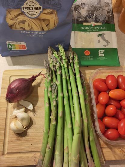 Ein paar der Zutaten. Darunter Knoblauch, Zwiebel, grüner Spargel, Tomaten, Pasta und Gorgonzola.