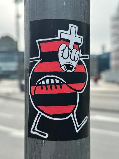 a sticker with a drawing of a weird little guy. The character is shaded in red and black horizontal stripes, has a hand emerging from above its eye giving a middle finger that turns into a cross, and looks pissed off.
