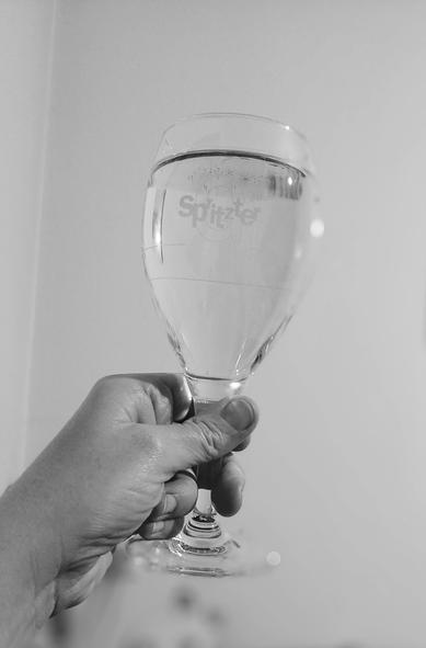 Schwarz-weiß-Aufnahme eines erhobenen Spritzerglases.