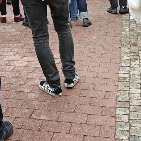 A pair of converse style shoes with the typical two-tone checks in black and white on the sides.