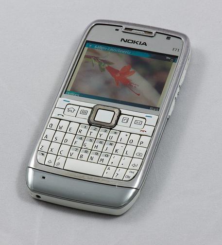 A photo of a Nokia E71 cellphone. It has a screen on its upper half, and the lower half has a few application buttons, such as Send, End, Home, and Email, and a QWERTY keyboard.