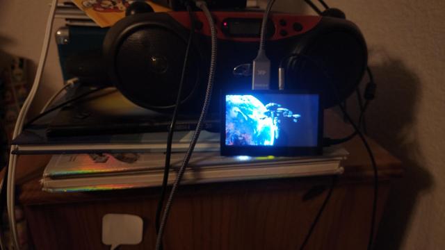 A photo of a small touchscreen and red/black radio and speaker system.