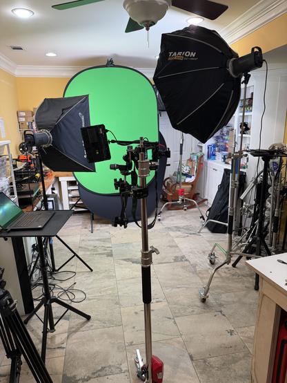 A disastrous mess of photography gear, screens, and lights in an otherwise dangerously cluttered room.