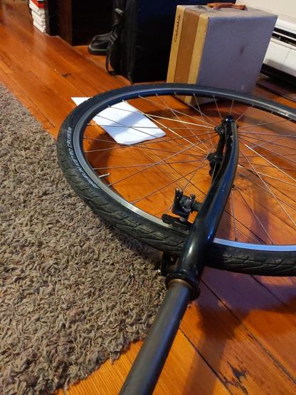 A cyclocross bicycle fork, off of the frame for measurements. In the background is a 300(?) CD Case Logic portable case, next to an even older portable Columbia record player case.