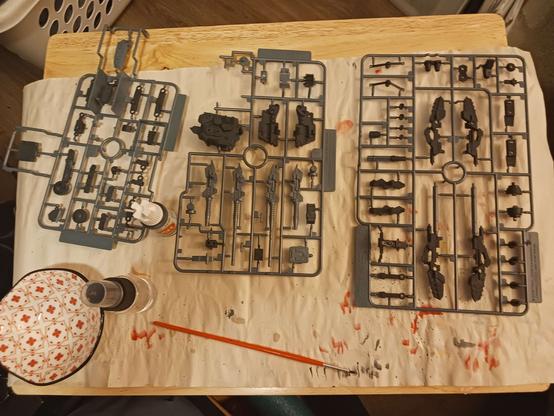 A photograph of three of the sprues from the previous post on the command wolf paint job. Most of the parts on them are painted in lead grey paint, though the one in the middle notably is half-unpainted, as described.