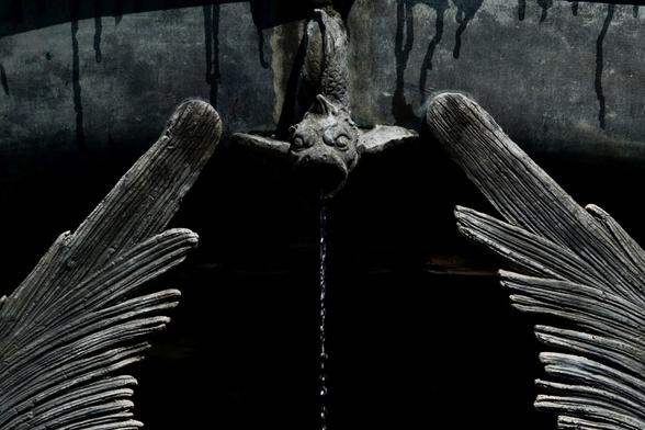 A metal dragon head spitting water and two wings