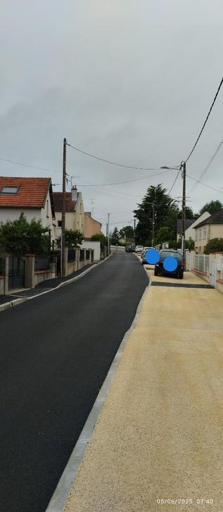Une rue avec des bagnoles sur les nouveaux trottoirs