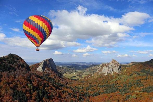 Montgolfière multicolore survolant les volcans d'Auvergne (photo iStock/Sablin)