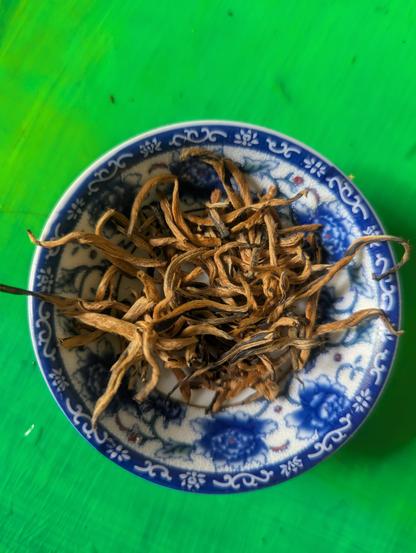 Un petite boule chinois avec des fleurs en bleu.
Avec un tas thè. Yunnan d'or, les feuilles sont des fils longs en or.