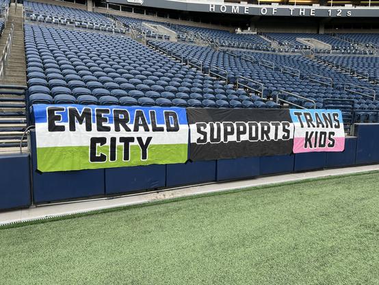 Rail banners with the text, “Emerald City Supports Trans Kids”