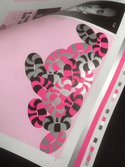 Photo d'une page du prochain programme du Pacbo (salle de spectacle à Orchie) où figure des bouées imprimées en rose fluo, argent et noir.