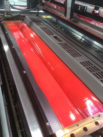 Photo d'une rotative offset pleine d'encre rose fluo