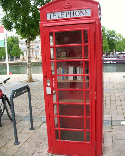 An old red telephone box repurposed as a little free library in the centre of the french city Verdun.