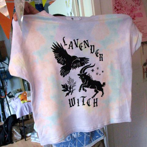 Our designer holds up a light coloured shirt with the silkscreen design. His face and body are not visible because the are hidden behind the shirt.