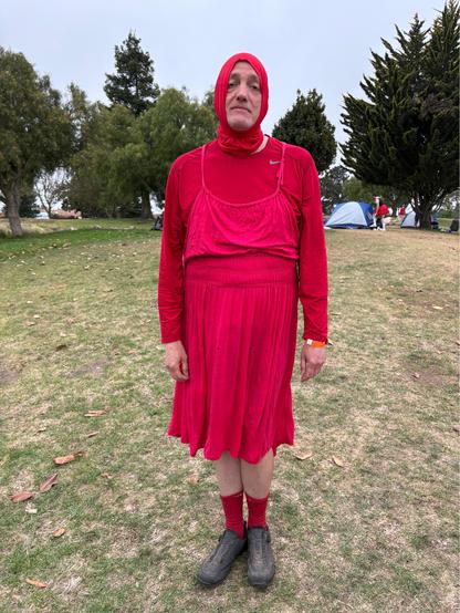 Me in a frumpy red dress and hood and bicycle shoes