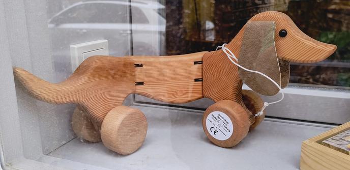 Houten teckel op wieltjes met een touwtje en leren oortjes.