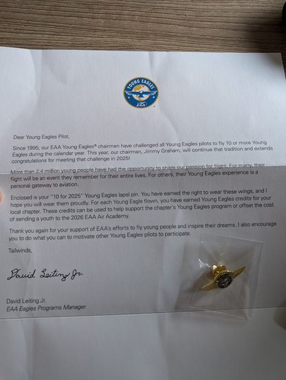 A letter from the EAA Eagles Programs Manager that reads:

Dear Young Eagles Pilot,

Since 1995, our EAA Young Eagles chairmen have challenged all Young Eagles pilots to fly 10 or more Young Eagles during the calendar year. This year, our chairman, Jimmy Graham, will continue that tradition and extends congratulations for meeting that challenge in 2025!

More than 2.4 million young people have had the opportunity to share our passion for flight. For many, their flight will be an event they remember for their entire lives. For others, their Young Eagles experience is a personal gateway to aviation.

Enclosed is your "10 for 2025" Young Eagles lapel pin. You have earned the right to wear these wings, and I hope you will wear them proudly. For each Young Eagle flown, you have earned Young Eagles credits for your local chapter. These credits can be used to help support the chapter's Young Eagles program or offset the cost of sending a youth to the 2026 EAA Air Academy.

Thank you again for your support of EAA's efforts to fly young people and inspire their dreams. I also encourage you to do what you can to motivate other Young Eagles pilots to participate.

Tailwinds,
David Leiting Jr.
EAA Eagles Programs Manager