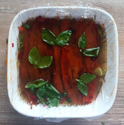 in einer Schale das mit der Flüssigkeit begossene Gemüse mit Basilikum dekoriert.