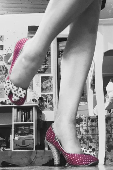 Woman wearing red and spotty high heels in a Black and White focus on her legs