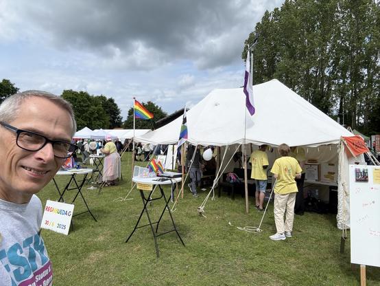 Selfie foran standen: et stort telt med forskellige boder, herunder til ansigtsmaling, “lån en levende bog” og “lav din egen badge”