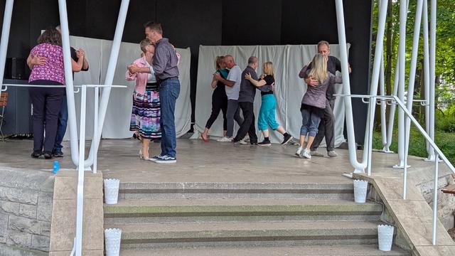 Fünf Paare tanzen Tango in einem Pavillon