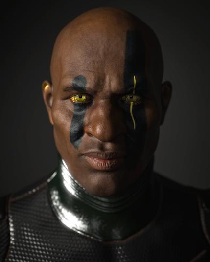 This image is a highly detailed cyberpunk-style portrait of a powerful male figure. He is bald, with dark brown skin and a strong, confident expression. His golden-yellow eyes glow unnaturally, suggesting cybernetic enhancement or magical augmentation common in the Shadowrun universe. Two bold, vertical black stripes are painted down his face, starting above the eyebrows and running over the eyes to the cheeks. One of these stripes is split by a glowing yellow circuit-like line running alongside his right eye, adding a high-tech visual cue.

He wears a glossy, dark armored suit with a textured hexagonal pattern that reflects ambient light subtly, suggesting futuristic material. The lighting is dramatic, casting one side of his face in shadow while highlighting the texture of his skin and the gleam of his enhanced eyes. The dark background isolates him, giving a sense of focus and authority, as if he's a street samurai or elite operative from a dystopian future.