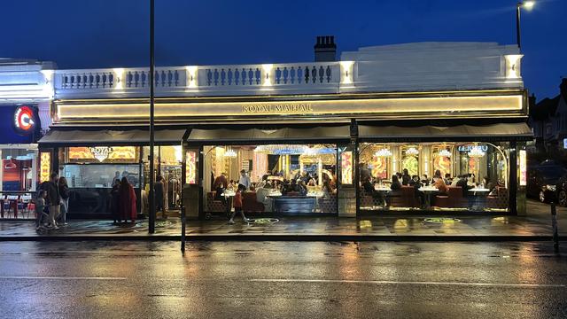 Royal Mahal restaurant, lit up at night, in the rain.
