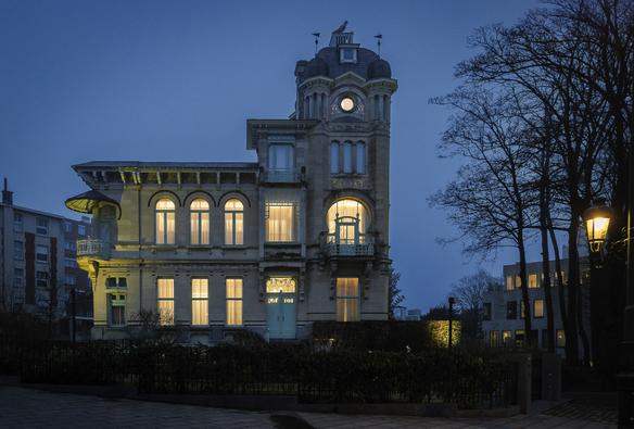Illuminated Art Nouveau Mansion by architect Leon Delune (1904) in Brussels, at blue hour, on a foggy winter day.
