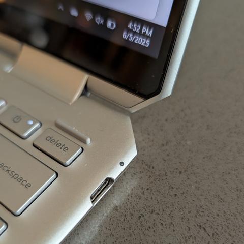 One of the USB-C ports on an HP Spectre x360 laptop, with the laptop's battery-charge icon visible in the Windows 11 taskbar.