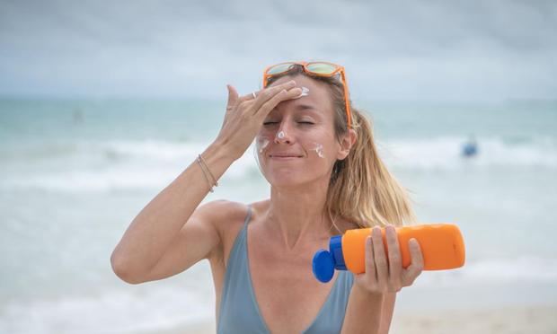 Una mujer poniéndose crema solar (Getty Images)