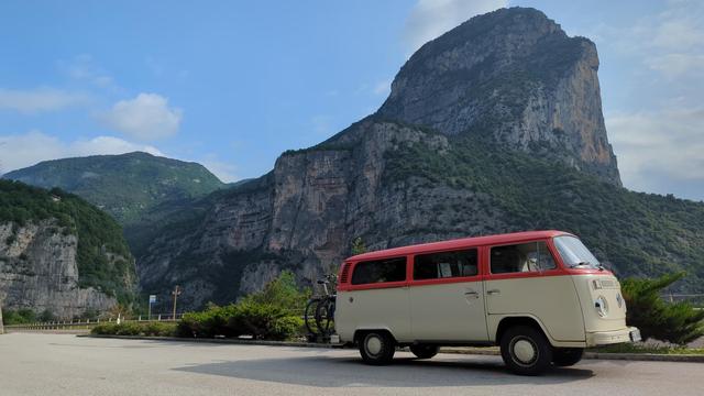 Volkswagen Bus in front of rocky mountain landscape.