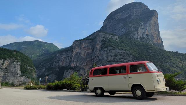 Volkswagen Bus in front of rocky mountain landscape.